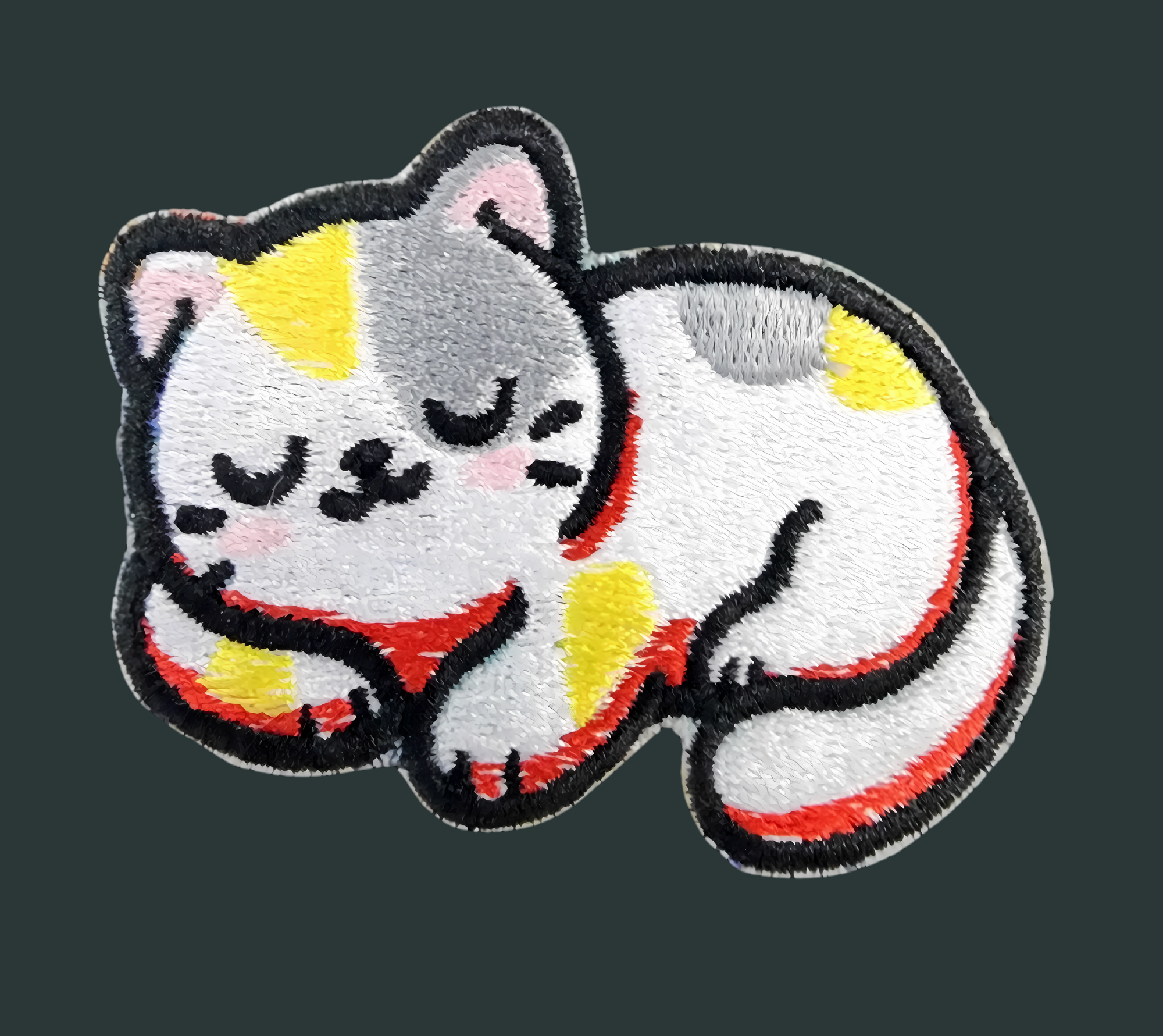 Iron-on embroidered patch of a cute sleeping cat with yellow and orange spots on a dark background